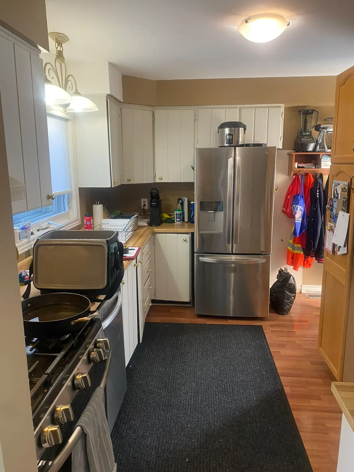 The same galley kitchen before the renovation, with dated oak and white cabinets